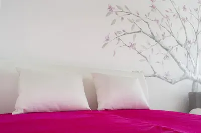 two white pillows sitting on a bed with pink sheets at Apartment Lilly in Belgrade