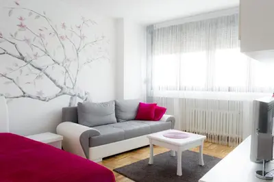 a living room with a couch and a tree mural at Apartment Lilly in Belgrade