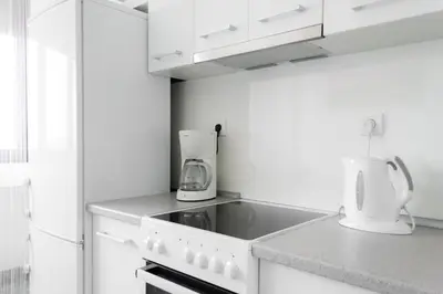 a kitchen with white cabinets and a stove top oven at Apartment Lilly in Belgrade