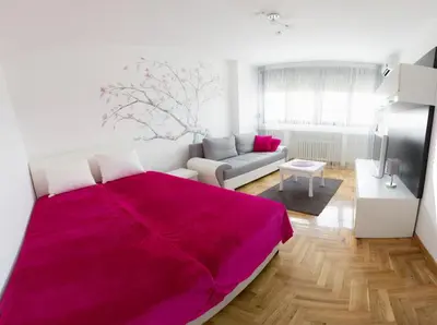 a bedroom with a large pink bed and a couch at Apartment Lilly in Belgrade