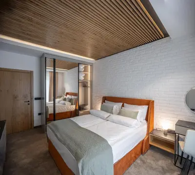 a bedroom with a large bed with a brick wall at Maison Royale Premium Apartment in Belgrade