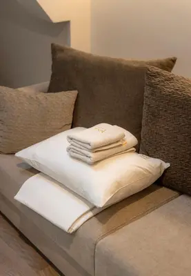 a stack of towels sitting on a couch at Maison Royale Premium Apartment in Belgrade