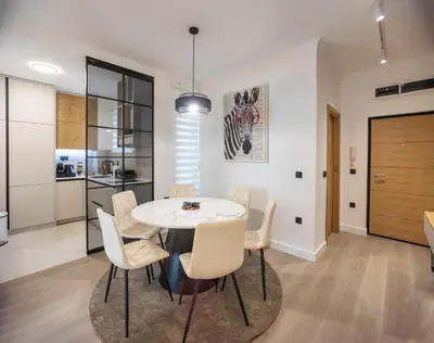 a kitchen and dining room with a white table and chairs at Maison Royale Premium Apartment in Belgrade