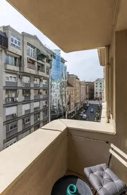 a balcony with a table and a view of a city at Maison Royale Premium Apartment in Belgrade