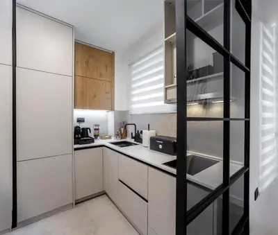 a kitchen with white cabinets and a glass wall at Maison Royale Premium Apartment in Belgrade