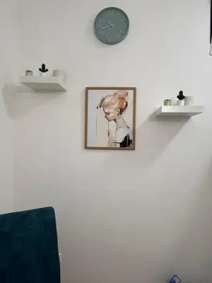 a clock on a wall with a picture of a woman at Forests nest in Belgrade