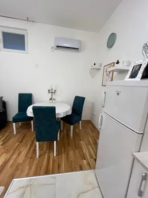 a kitchen with a white refrigerator and a table with chairs at Forests nest in Belgrade