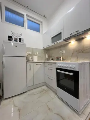 a kitchen with white appliances and white cabinets at Forests nest in Belgrade