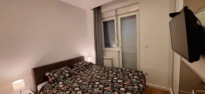 a bedroom with a bed and a flat screen tv at Miletić Lux in Zemun