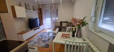 a small living room with a table and a couch at Miletić Lux in Zemun