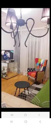 a living room with a table and a chair and a tv at Belvile one bedroom apartment in Belgrade