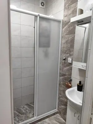 a bathroom with a shower and a toilet and a sink at Aria Central Apartment in Smederevo