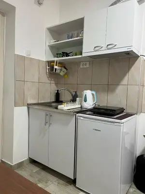 a small kitchen with white cabinets and a sink at Aria Central Apartment in Smederevo