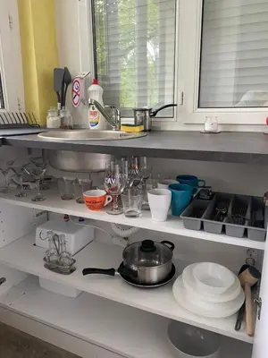 a kitchen shelf filled with dishes and a sink at Apartman Vera