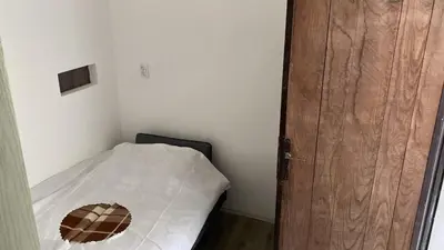 a small room with a bed and a wooden door at Apartman Vera