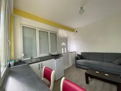 a kitchen and living room with a couch and a table at Apartman Vera
