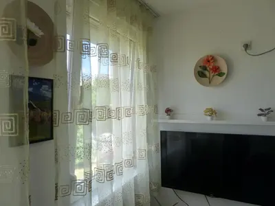 a living room with a television and a curtain at Tackica 13 Apartment in Belgrade
