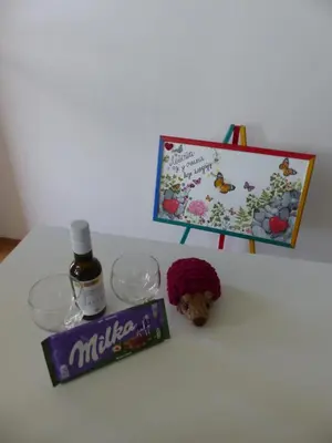 a table with a bottle of alcohol and a box of wine at Tackica 13 Apartment in Belgrade