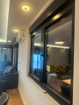 a room with a window with a couch and a table at Infinity Lux Residence in Novi Banovci