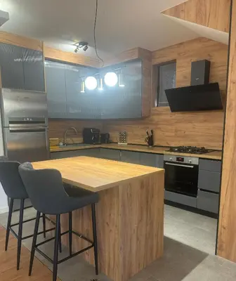 a kitchen with a wooden table and chairs in it at Infinity Lux Residence in Novi Banovci