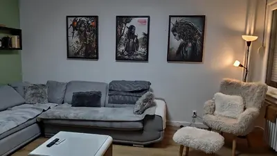 a living room with a couch and some pictures on the wall at 14th Heaven Apartment in Belgrade