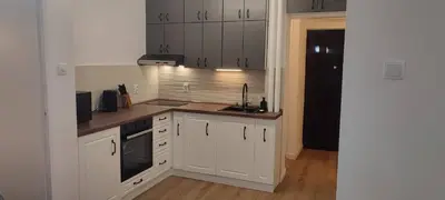 a kitchen with white cabinets and a sink at 14th Heaven Apartment in Belgrade