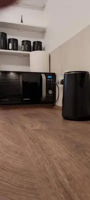 a microwave oven sitting on a wooden floor in a room at 14th Heaven Apartment in Belgrade