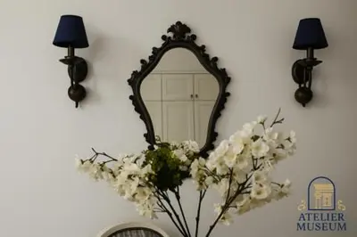 a mirror on a wall with a vase of flowers at Atelier Museum in Belgrade