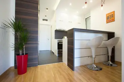 a room with two white chairs and a red vase at The Boutique Apartment in Belgrade