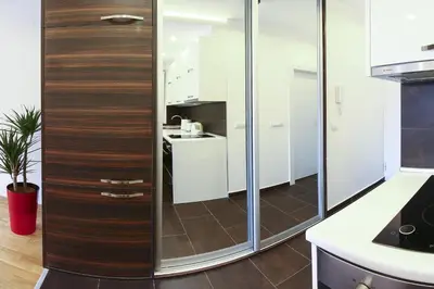 a kitchen with white cabinets and glass walls at The Boutique Apartment in Belgrade