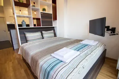 a bedroom with a bed with a tv on the wall at The Boutique Apartment in Belgrade