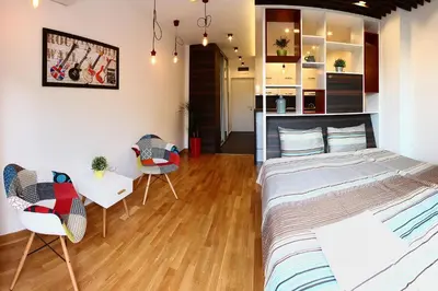 a bedroom with a bed and a table and chairs at The Boutique Apartment in Belgrade