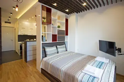 a bedroom with a large bed and a kitchen at The Boutique Apartment in Belgrade