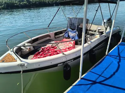 a small boat is docked on the water at Savska Bajka in Zabrežje