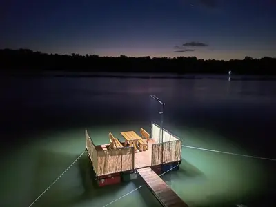 a dock in the middle of a lake at night at Savska Bajka in Zabrežje