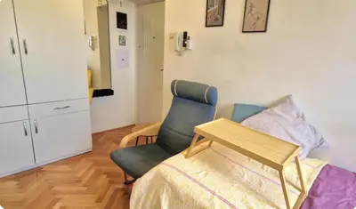 a bedroom with a chair and a bed and a table at Mileshevska Studio in Belgrade