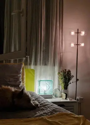 a bedroom with a bed with a clock and a lamp at Mileshevska Studio in Belgrade