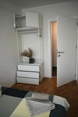 a bedroom with a white dresser and a mirror at Apartman Play in Belgrade