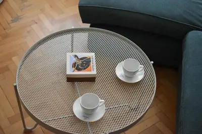 a coffee table with two cups and a book on it at Apartman Play in Belgrade