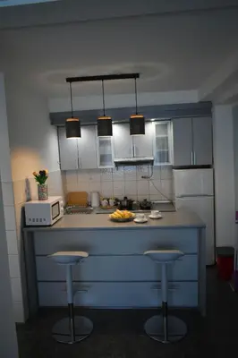 a kitchen with a blue island with two bar stools at Apartman Play in Belgrade
