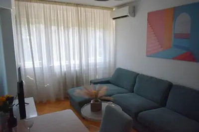 a living room with a blue couch and a table at Apartman Play in Belgrade