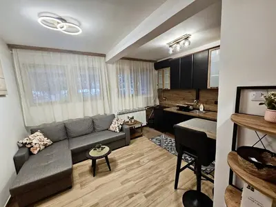a living room with a couch and a kitchen at Apartman Sandra in Belgrade