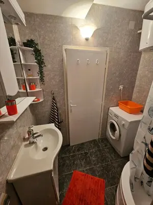 a bathroom with a sink and a washing machine at Apartman Sandra in Belgrade