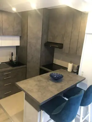 a kitchen with a table and two blue chairs at Beograd stan na dan in Novi Beograd