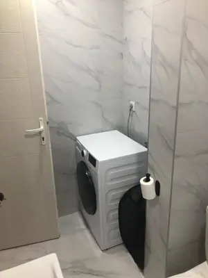 a bathroom with a washing machine and a toilet at Beograd stan na dan in Novi Beograd