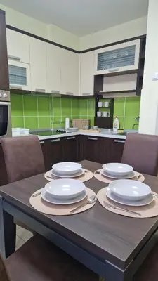 a kitchen with a table with white plates on it at Apartman Pegaz in Lazarevac
