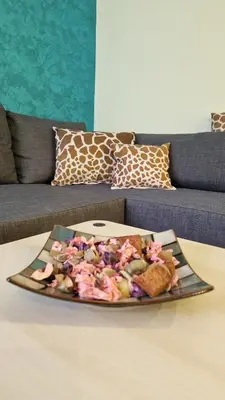 a plate of food on a table in front of a couch at Apartman Pegaz in Lazarevac