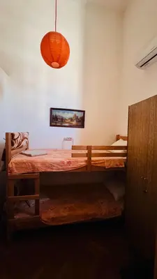 a bedroom with a large wooden bed with a hanging light at BW Hostel in Belgrade