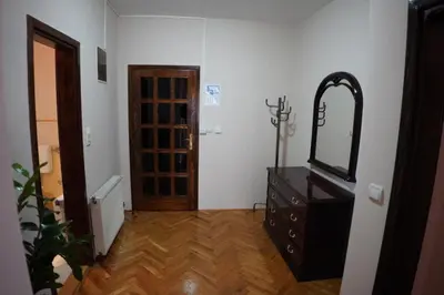 a room with a dresser with a mirror and a door at Apartmani Kula - Lux Apartman in Novi Banovci