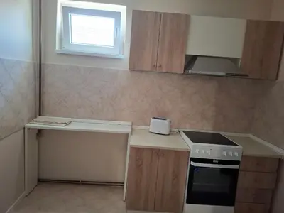 a small kitchen with a stove and a counter at Apartmani Kula - Lux Apartman in Novi Banovci
